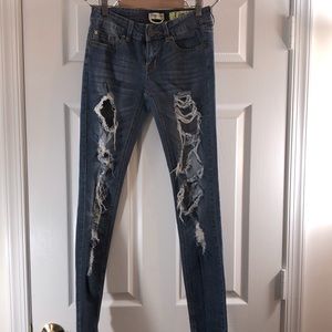 Blue denim distressed skinny leg jeans.
